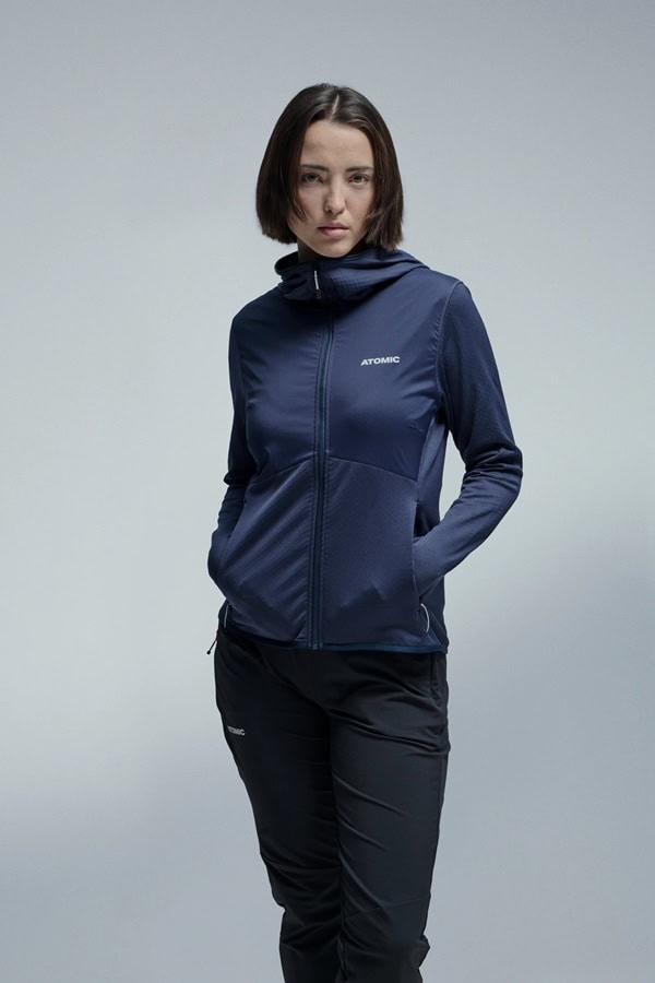 Atomic sporty navy blue winter jacket and black trousers, ideal for cold outdoor activities, showcasing high-performance winter gear for enthusiasts.