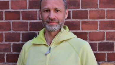 Warm male portrait in front of a brick wall, highlighting winter outdoor clothing and winter gear essentials for winter enthusiasts.
