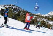 Kids skiing on snow at Imaginarium Winter wonderland, with blue sky and snowy mountain background - Your source for everything winter.