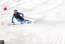 Skiing enthusiast carving through fresh snow on a sunny winter day, emphasising winter sports and outdoor adventure.