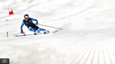 Skiing enthusiast carving through fresh snow on a sunny winter day, emphasising winter sports and outdoor adventure.