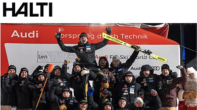 Audi FIS Ski World Cup team celebrating victory on podium with skis and winter sports gear.