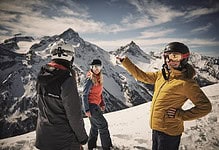 Exploring winter sports in snowy mountains with smiling skiers in helmets and jackets.