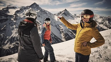 Exploring winter sports in snowy mountains with smiling skiers in helmets and jackets.