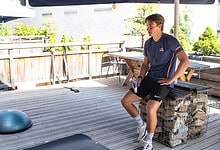 Refreshing outdoor space with winter sports equipment, featuring a young man relaxing after a workout, perfect for winter enthusiasts and fitness lovers seeking winter-themed relaxation and outdoor activities.