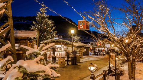 Snow-covered festive market scene with Christmas trees and holiday lighting at dusk, showcasing winter festivities and holiday shopping atmosphere.