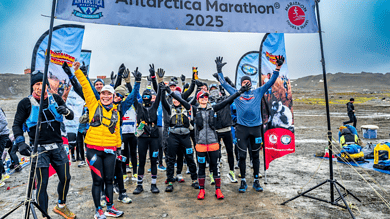 Antarctica Marathon 2025 participants celebrating at the start line, showcasing winter marathon endurance amidst icy terrain for winter sports enthusiasts.