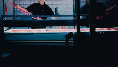 Indoor ice rink showcasing winter sports equipment with two individuals preparing gear, highlighting winter activity preparations.