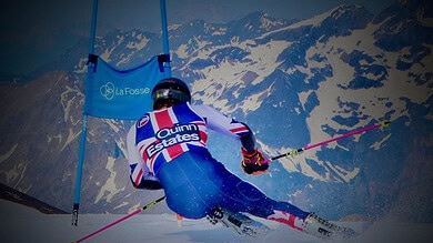 Skier racing downhill on a snowy mountain slope during a competitive event.
