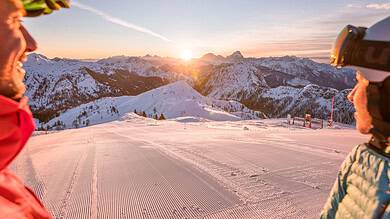 Scenic winter landscape in Carinthia, Austria with snow-covered mountains at sunrise, perfect for skiing and family holidays.