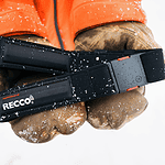 Close-up of a winter safety headlamp held in gloved hands, suitable for outdoor winter activities and snow safety.