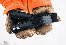 Close-up of a winter safety headlamp held in gloved hands, suitable for outdoor winter activities and snow safety.