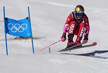 Female alpine skier in red and pink racing suit navigating a slalom course during a World Cup event in Sölden, Austria.