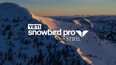 Snowy mountain landscape at dawn with YETI Snowbird Pro by STIFEL logo overlay, winter skiing scenery.